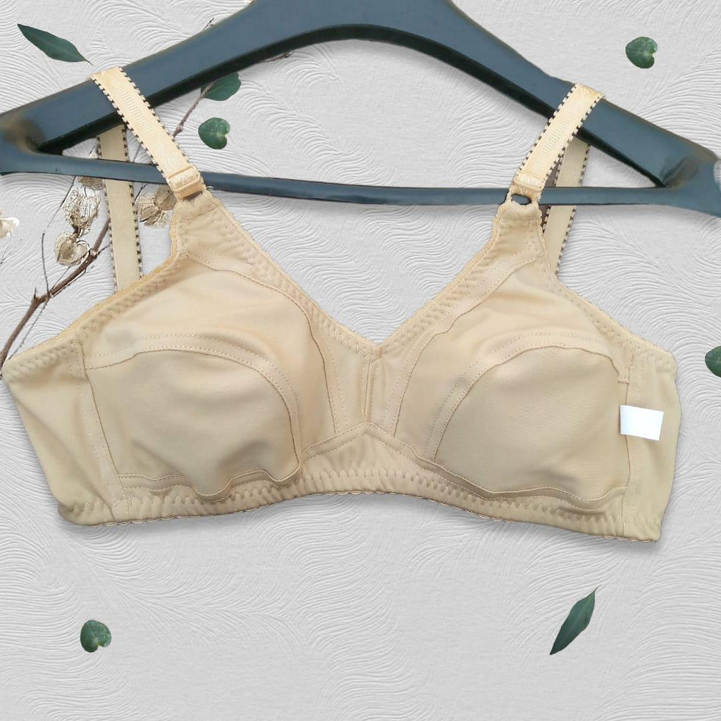 Beige bra on a hanger with a light background