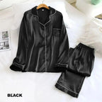 Black satin pajama set on a white bed