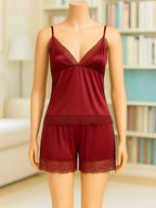 A two-piece lingerie set in deep burgundy red displayed on a mannequin. The set includes a camisole top with thin straps and lace trim at the bust, and matching lace-trimmed shorts.